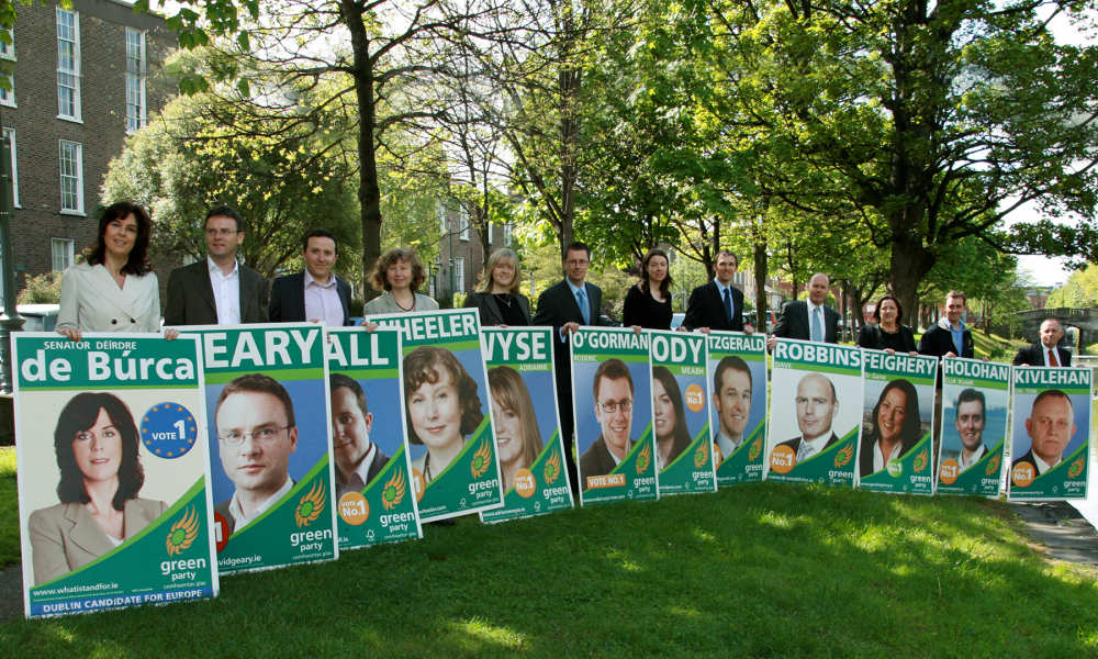A photo along the canal in Dublin. A line-up of people each holding a Green Party election poster with their name on it.