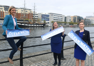 Senators Róisín Garvey, Pauline O'Reilly and Pippa Hackett hold signs reading "Water is Life" at the Liffey, Dublin.