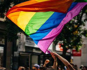 Pride flag being waved at a parade