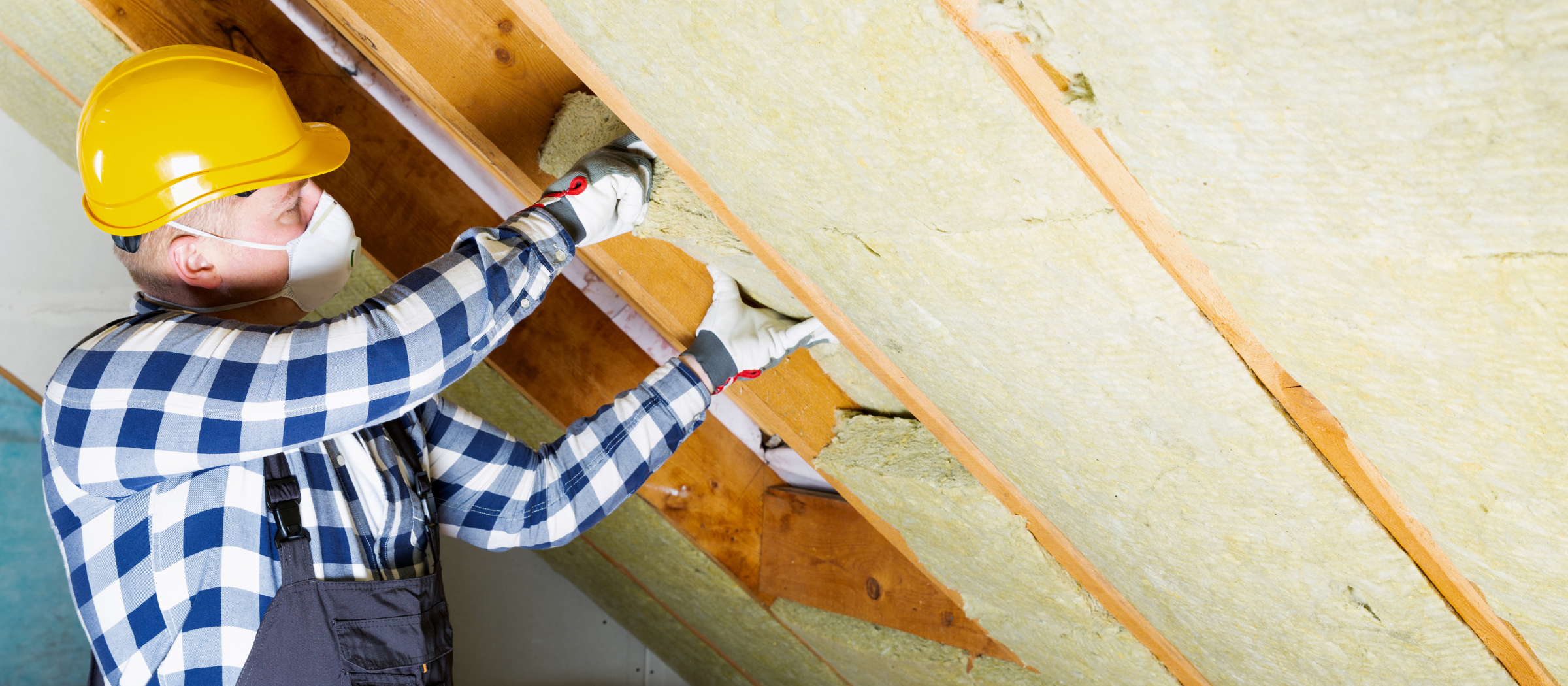 Man installing insulation in attic