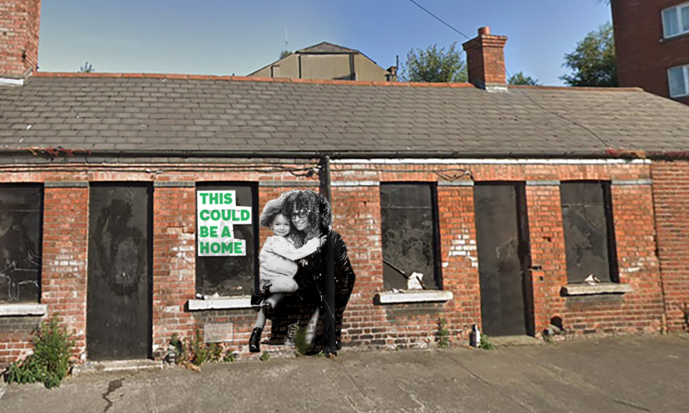 On a boarded up house there is an image of a mother and her child with the slogan, "This could be a home".