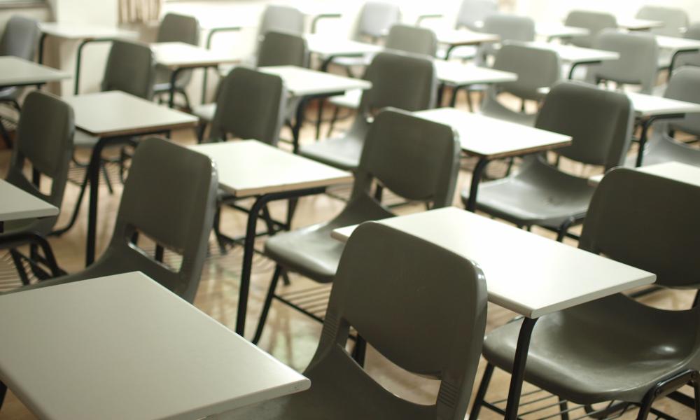 Empty classroom tables and chairs