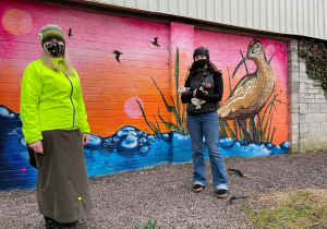 Artist Ciara McKenna and Green Party LEA Rep Anne-Marie Fuller with a mural of a Curlew at Tralee–Fenit Greenway, County Kerry.
