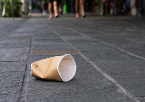 A used paper coffee cup dropped on the street